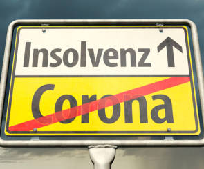 Corona und Insolvenz steht auf einem Straßenschild 