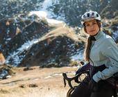 Frau mit Fahrradhelm in den Bergen