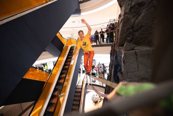 Mann klettert auf Slackline in Store