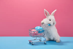 weißer Hase mit Einkaufswagen mit Eiern 