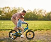Ein Vater bringt seinem Sohn das Radfahren bei